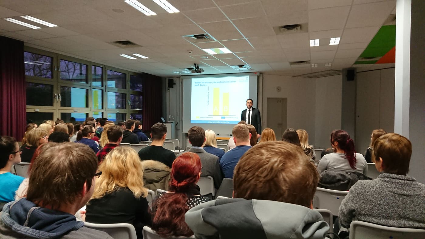 Ömer Özbekler spricht vor einem voll besetzten Saal.